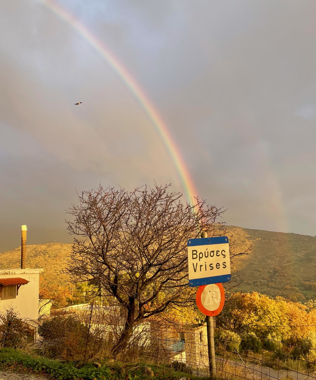The village sign, rainbow behind